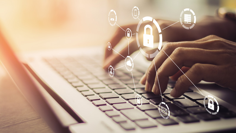 hands typing on a laptop keyboard, with a graphic of a padlock superimposed