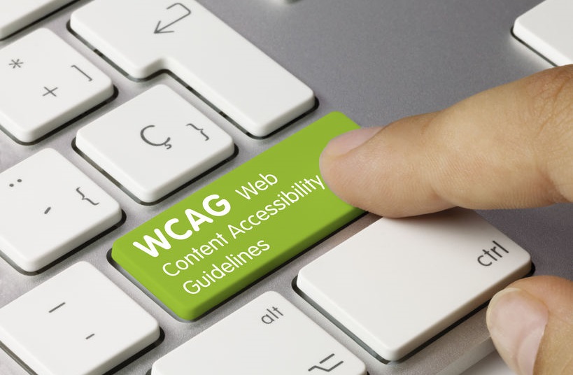 WCAG Web Content Accessibility Guidelines written on the green key of the metal keyboard. Key that is pressed with the finger.