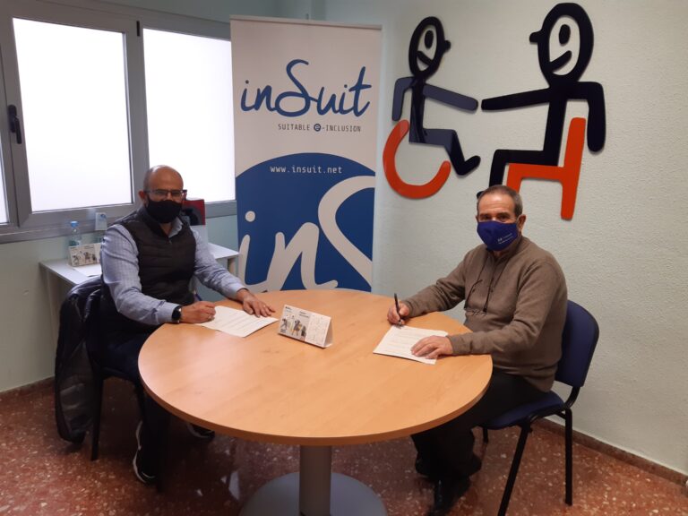 juan antonio partner of insuit is sitting in a table with another person signing the collaboration agreement with cocemfe valencia.