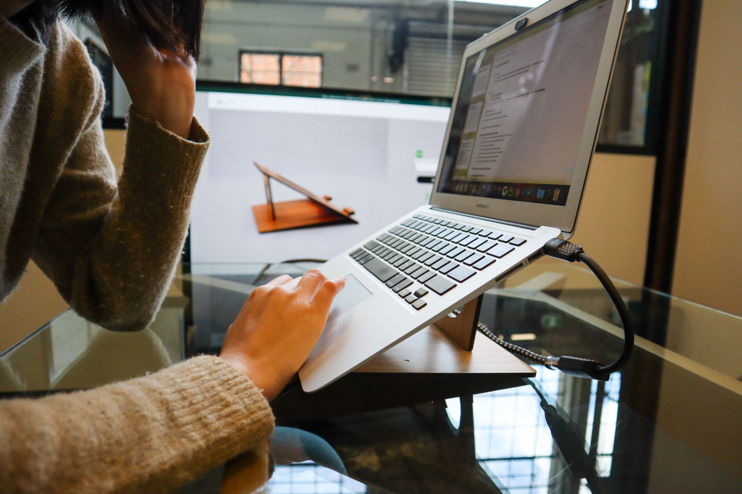 una persona utilizando su ordenador portátil en una mesa de trabajo