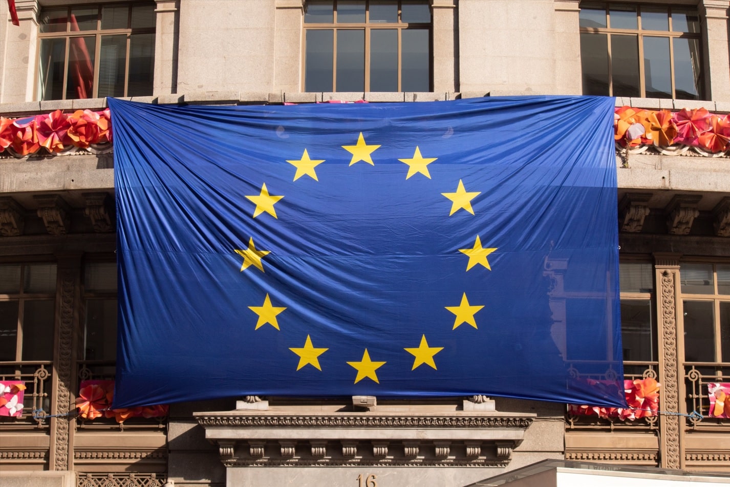 Bandera de la unión europea colgada en una fachada de un edificio.