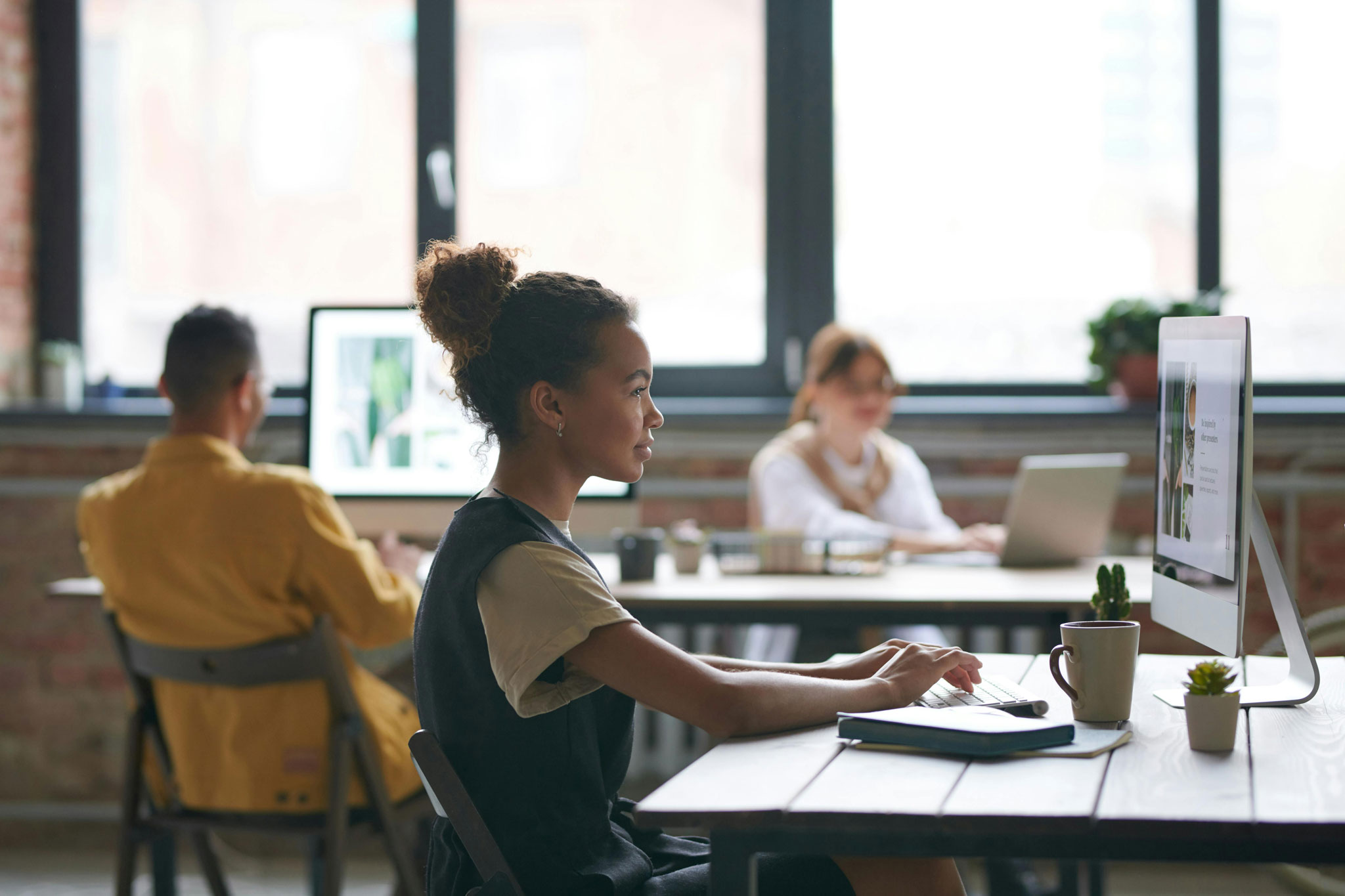 Accesibilidad en Argentina: Un grupo de personas trabajan en sus computadoras gracias a la accesibilidad digital en Argentina.