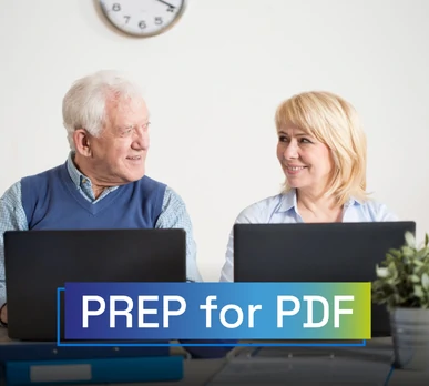 Hombre y mujer mayores frente a sus ordenadores portátiles, sonriendo mientras trabajan en un entorno accesible. Texto sobreimpreso: "PREP for PDF".