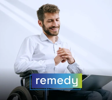 Hombre joven en silla de ruedas interactuando con un portátil, sonriendo. Representa el uso de herramientas de remediación digital. Texto sobreimpreso: "remedy".